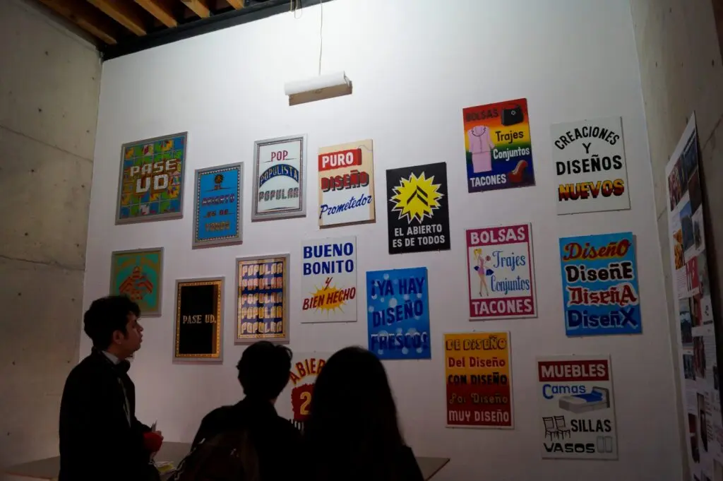  Visitantes observan una exposición de carteles y propuestas gráficas del Abierto de Diseño CDMX.
