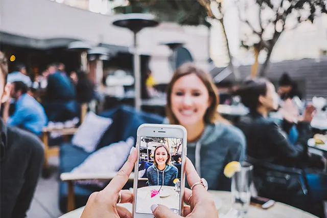 Persona tomando una fotografía con un teléfono celular
