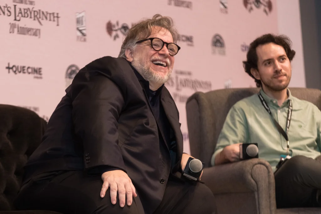 Guillermo del Toro sonríe durante una conversación en el Festival Internacional de Cine de Morelia 2026, acompañado por otro participante.

