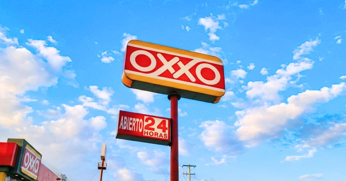 Letrero de OXXO con anuncio de servicio abierto las 24 horas.