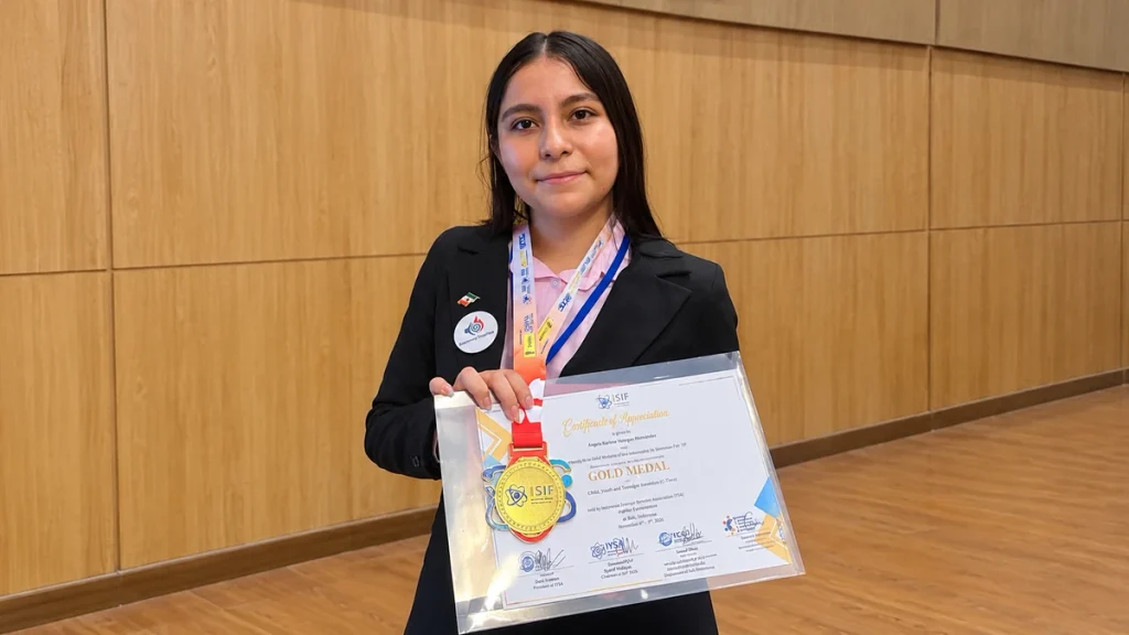 Ángela Karime Hernández Venegas muestra su medalla de oro y reconocimiento en la competencia internacional de ciencia ISIF 2026.
