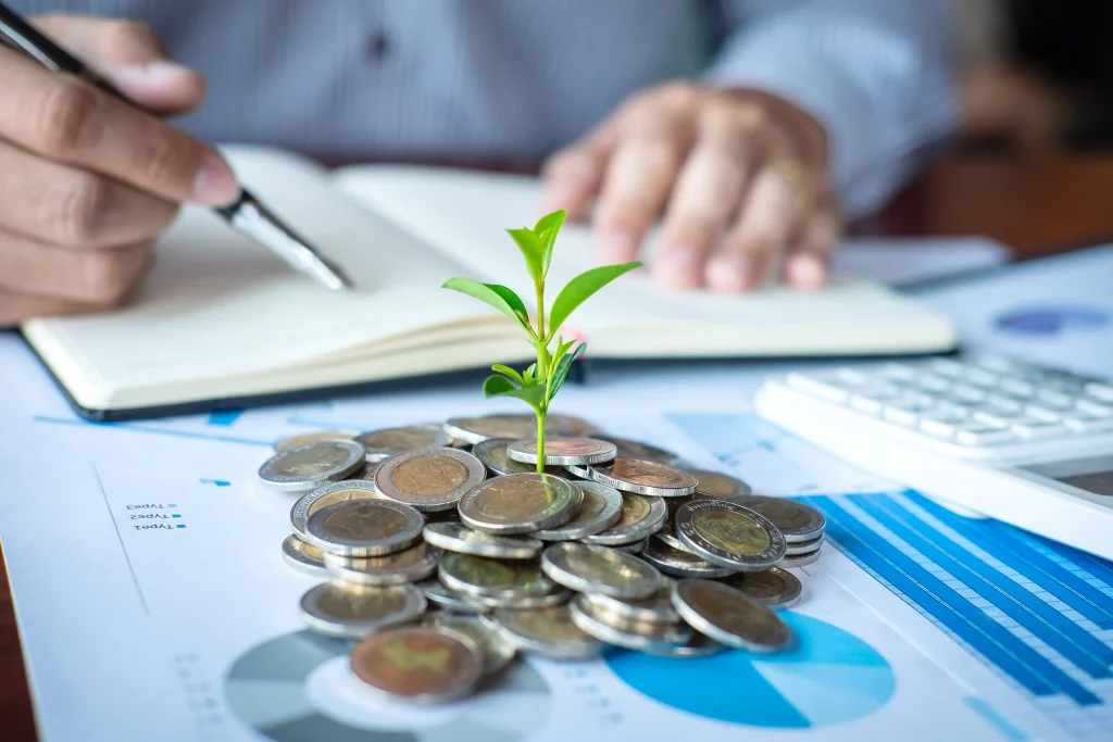Monedas y una planta representan el crecimiento y la planificación financiera.